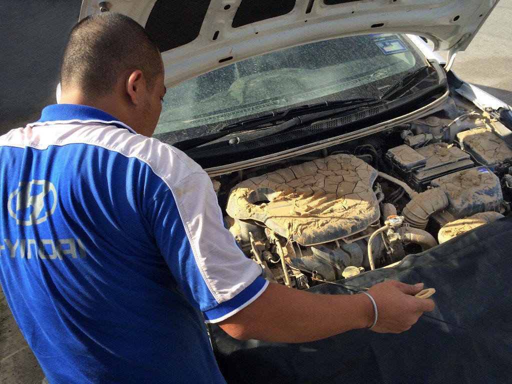 Hyundai technician inspecting a car that is damaged by the flood